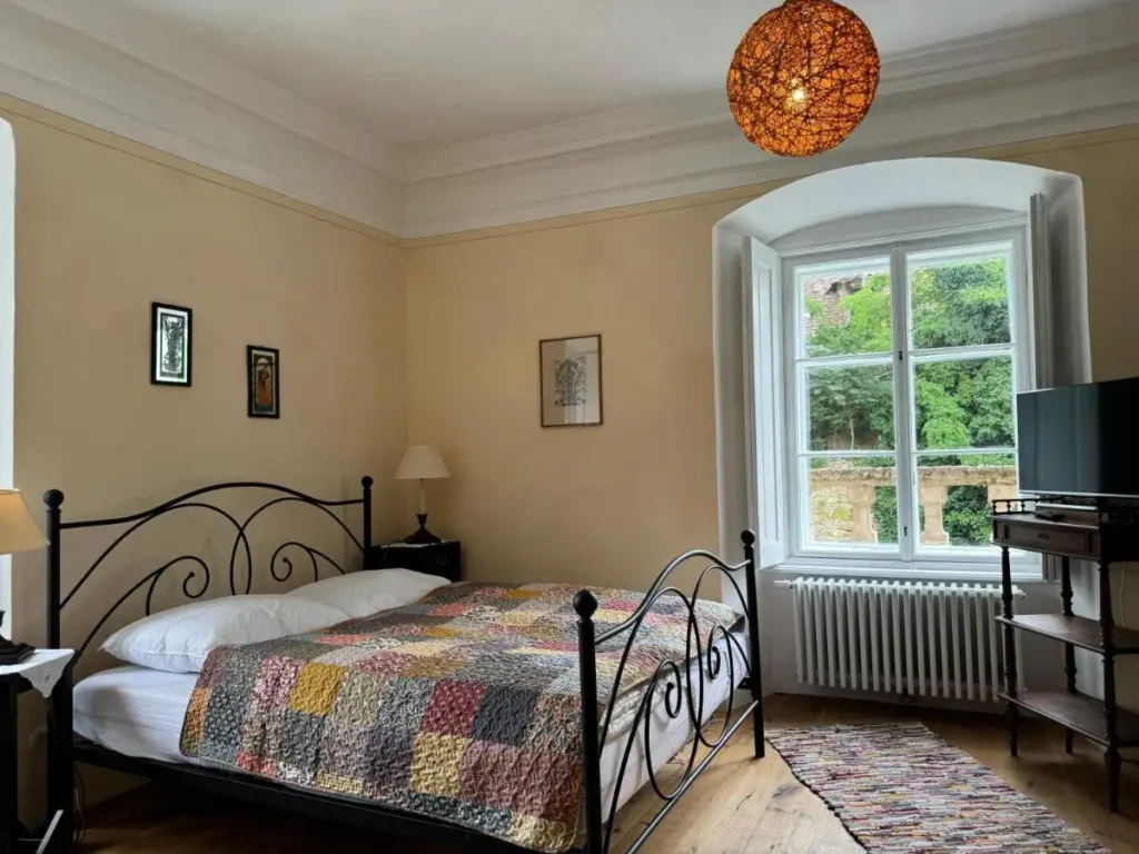 Schlafzimmer mit großem Doppelbett am Fenster
