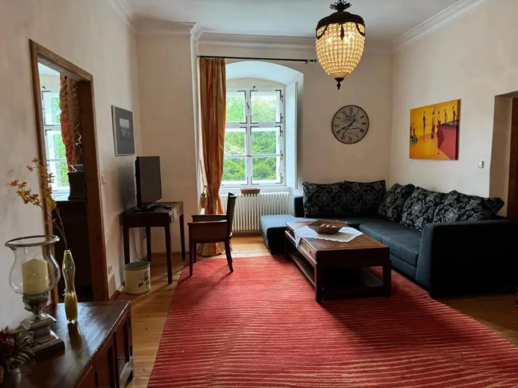 Wohnzimmer in einem Hotelzimmer mit einem großen dunklen Sofa